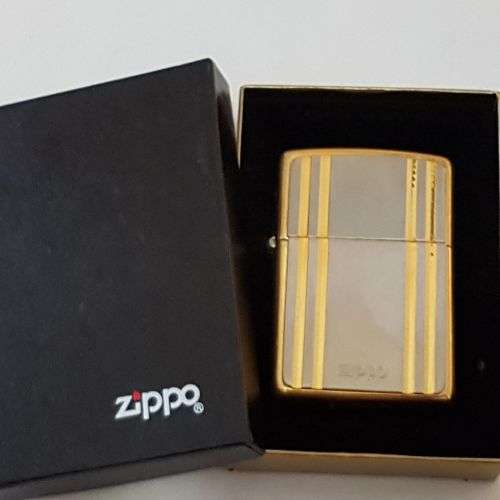 A stunning gold and silver detailed retro style authentic Zippo lighter in its original box