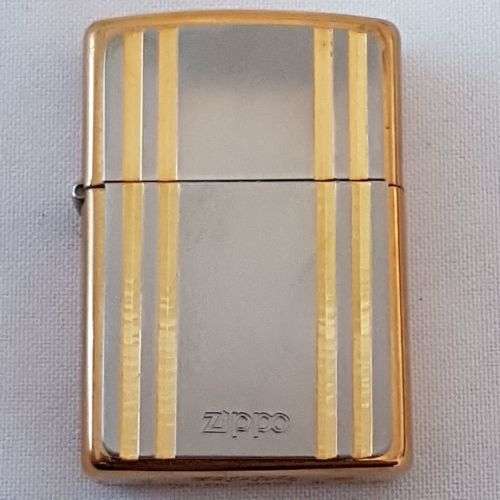 A stunning gold and silver detailed retro style authentic Zippo lighter in its original box
