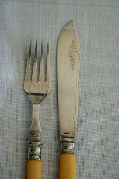 A superb vintage sterling silver cuff bone handle fish knife and fork set in its wooden canteen