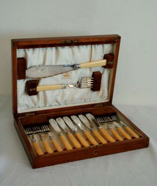 A superb vintage sterling silver cuff bone handle fish knife and fork set in its wooden canteen