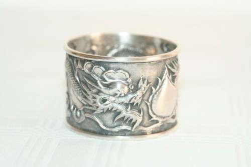 An incredible and rare Chinese solid silver "Dragon" napkin ring with amazing hand chased detailing