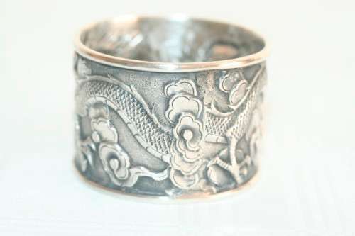 An incredible and rare Chinese solid silver "Dragon" napkin ring with amazing hand chased detailing