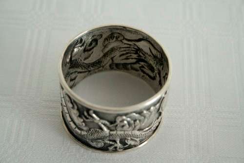 An incredible and rare Chinese solid silver "Dragon" napkin ring with amazing hand chased detailing