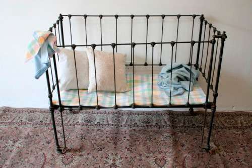 A stunning & rare antique (late 1800's) wrought iron baby's cot w/ dropside on its original castors