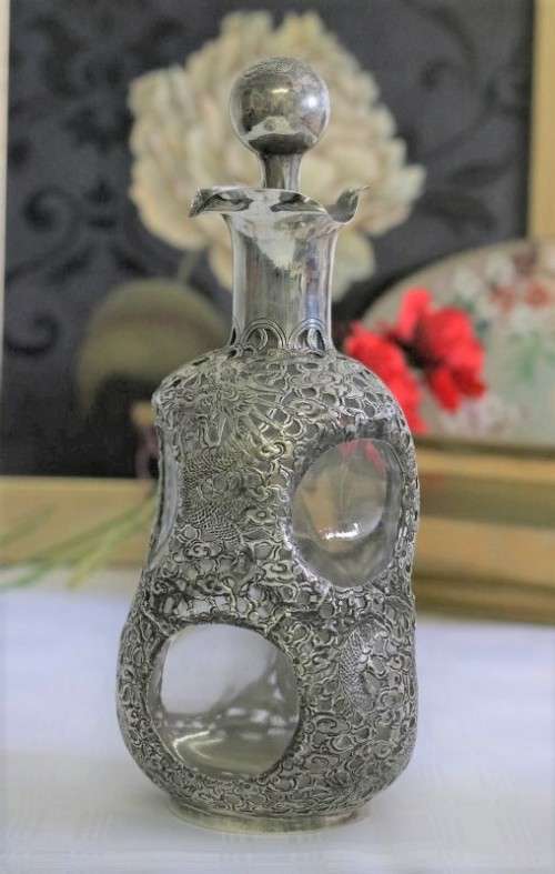 An incredible antique 3-sided 900 solid silver overlay decanter and stopper with a dragon motif
