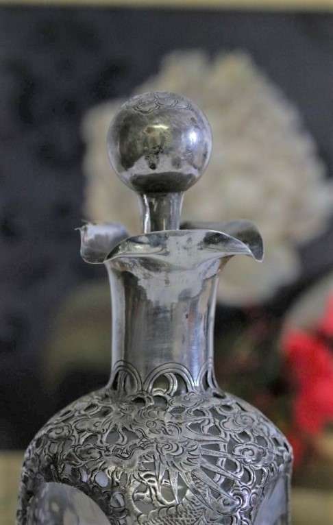 An incredible antique 3-sided 900 solid silver overlay decanter and stopper with a dragon motif