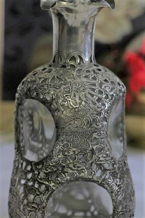 An incredible antique 3-sided 900 solid silver overlay decanter and stopper with a dragon motif