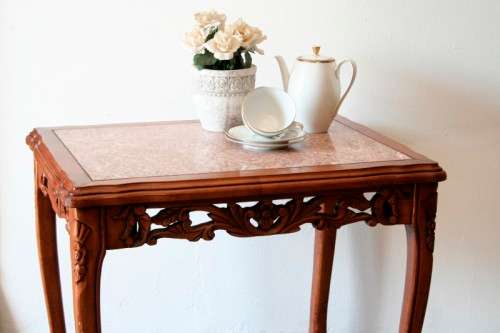A wonderful and stylish teak side table with a marble top and beautifully carved detailing