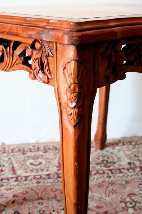 A wonderful and stylish teak side table with a marble top and beautifully carved detailing
