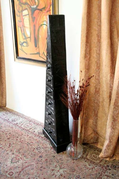 A beautiful tall Indonesian pyramid chest of drawers with stunning traditional hand carved detailing