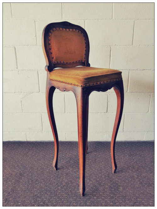An amazing and unusual antique Mahogany bar chair with long legs and a mustard colour upholstery!!
