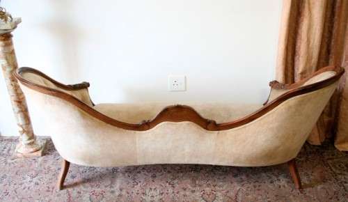 A beautiful, elegant carved Victorian sofa with deep button detailing and beige fabric.