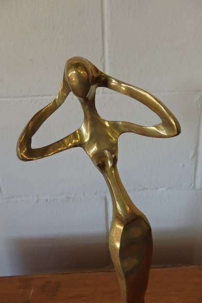 A beautiful tall ornamental brass abstract figurine on a wooden stand in wonderful condition