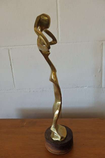 A beautiful tall ornamental brass abstract figurine on a wooden stand in wonderful condition