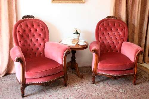 Two elegant hand carved Victorian arm chairs with deep button detailing & gorgeous pink fabric.
