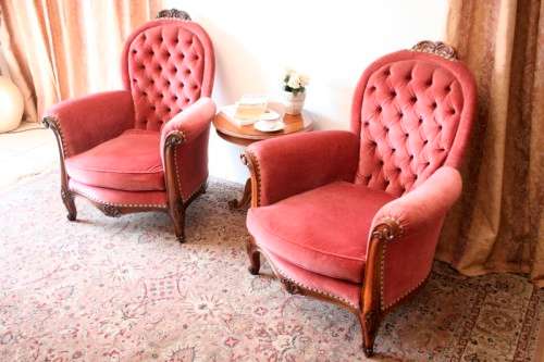Two elegant hand carved Victorian arm chairs with deep button detailing & gorgeous pink fabric.