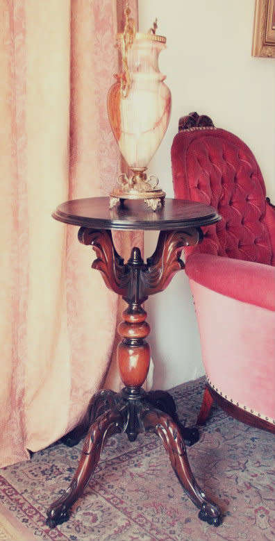 An exquisite hand-carved round Imbuia occasional/ side table with a solid turned centre base.
