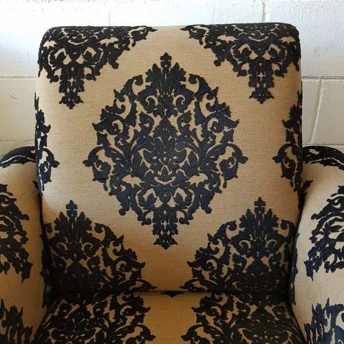 A one seater sofa chair upholstered in a stunning brocade fabric with wooden legs