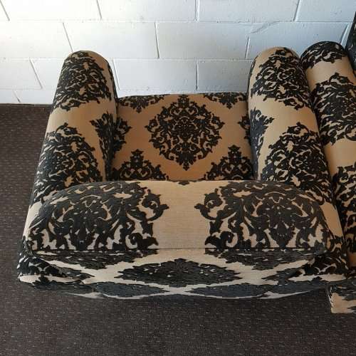 A one seater sofa chair upholstered in a stunning brocade fabric with wooden legs