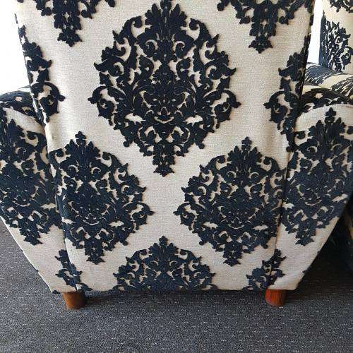 A one seater sofa chair upholstered in a stunning brocade fabric with wooden legs