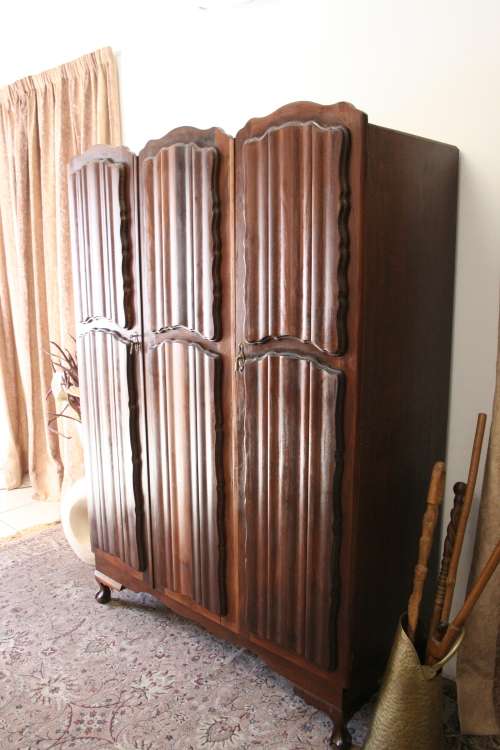 A stunning vintage Imbuia ball and claw three door wardrobe with three glass window drawers.