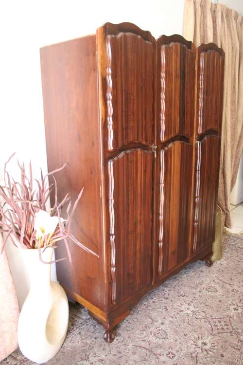 A stunning vintage Imbuia ball and claw three door wardrobe with three glass window drawers.
