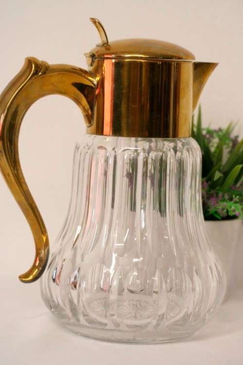 A spectacular lead crystal water jug with a cooler for ice, brass lid and handle in good condition