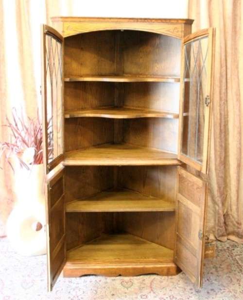 An exquisite vintage solid oak corner display cabinet with lead glass doors and a large cupboard.