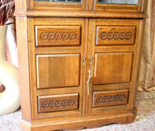 An exquisite vintage solid oak corner display cabinet with lead glass doors and a large cupboard.