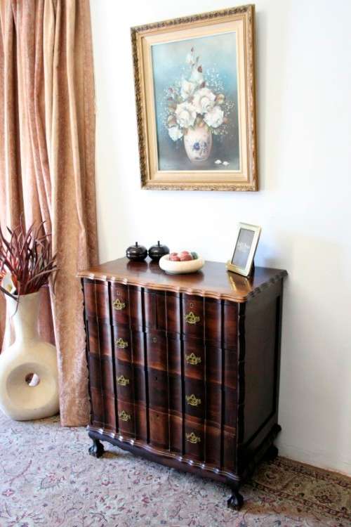 An exquisite vintage Imbuia 5-drawer chest of drawers with ornate handles and ample storage space