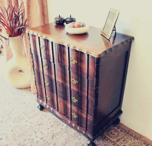 An exquisite vintage Imbuia 5-drawer chest of drawers with ornate handles and ample storage space