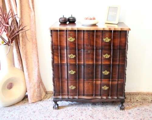 An exquisite vintage Imbuia 5-drawer chest of drawers with ornate handles and ample storage space