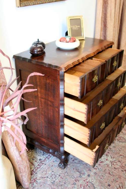 An exquisite vintage Imbuia 5-drawer chest of drawers with ornate handles and ample storage space