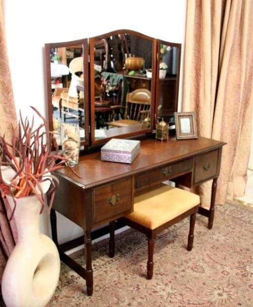An exquisite three-drawer Imbuia dressing table with side-folding mirrors and a stool