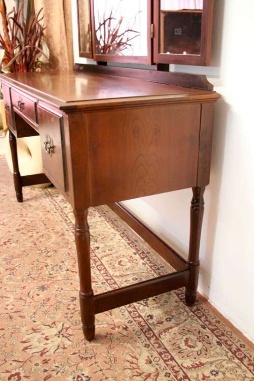 An exquisite three-drawer Imbuia dressing table with side-folding mirrors and a stool