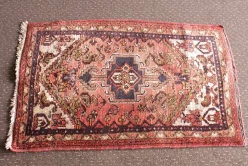 An awesome vintage/ antique? hand dyed Persian carpet (127cm x 80cm) with red and earthy tones