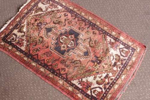 An awesome vintage/ antique? hand dyed Persian carpet (127cm x 80cm) with red and earthy tones