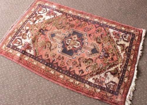 An awesome vintage/ antique? hand dyed Persian carpet (127cm x 80cm) with red and earthy tones