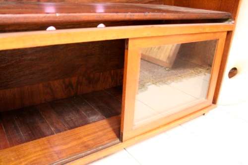 **RS17** A large Teak cabinet w/ fold away serving shelf, glass sliding doors, on original castors