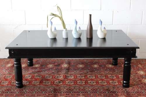 A stunning Indonesian Teak coffee table with clean lines, thick turned legs and carved detailing