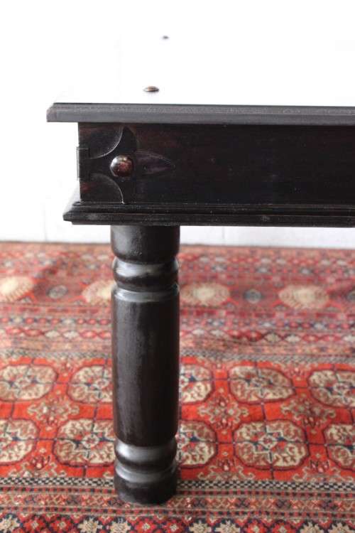 A stunning Indonesian Teak coffee table with clean lines, thick turned legs and carved detailing
