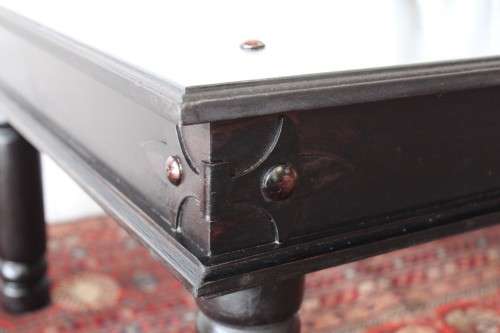 A stunning Indonesian Teak coffee table with clean lines, thick turned legs and carved detailing