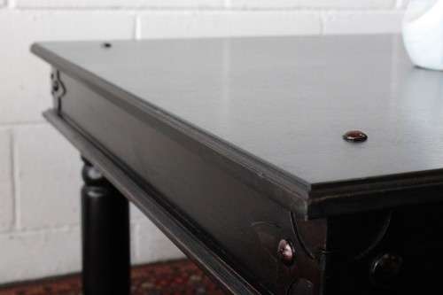 A stunning Indonesian Teak coffee table with clean lines, thick turned legs and carved detailing