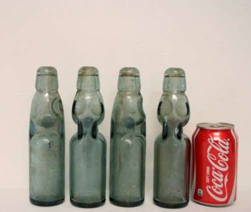 Four amazing antique (late 1800's) glass codd-neck bottles with their marbles in the bottles.