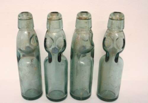Four amazing antique (late 1800's) glass codd-neck bottles with their marbles in the bottles.