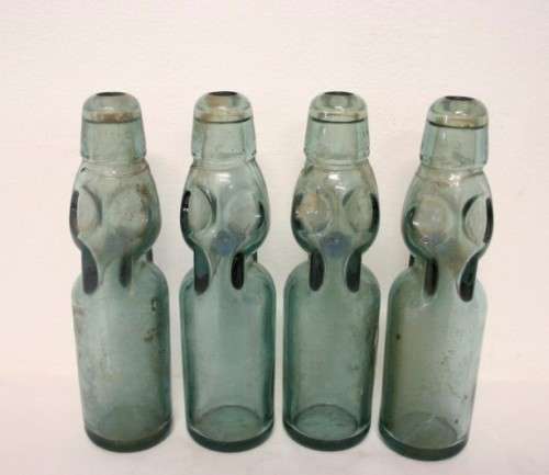 Four amazing antique (late 1800's) glass codd-neck bottles with their marbles in the bottles.