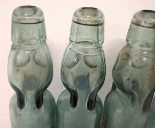 Four amazing antique (late 1800's) glass codd-neck bottles with their marbles in the bottles.