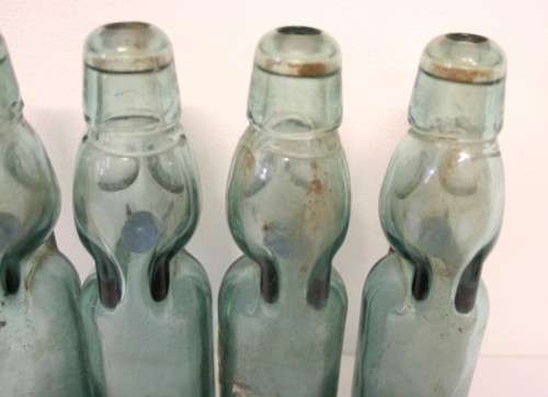 Four amazing antique (late 1800's) glass codd-neck bottles with their marbles in the bottles.