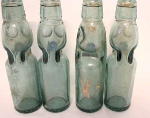 Four amazing antique (late 1800's) glass codd-neck bottles with their marbles in the bottles.
