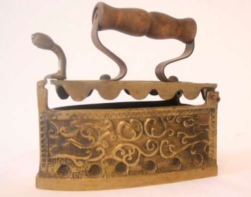 A fabulous very ornate antique brass sad iron/coal iron. Stunning as a display piece.